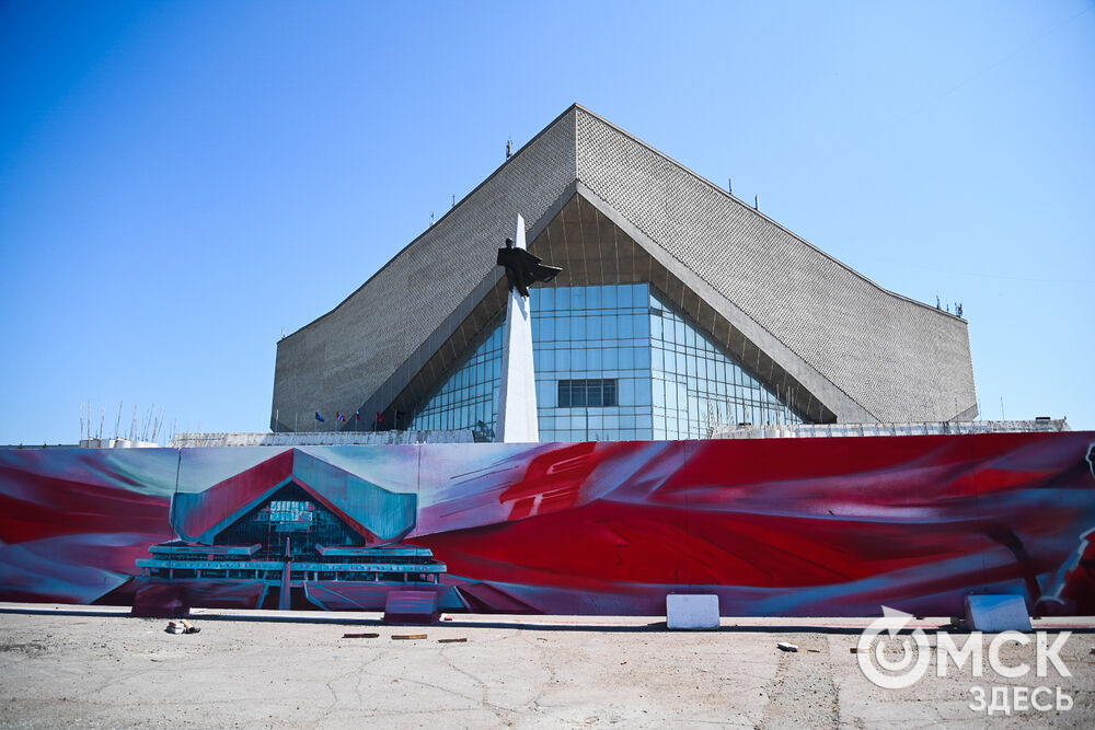 На бетонном заборе вокруг спорткомплекса имени Виктора Блинова теперь красуются красочные рисунки, отражающие историю ХК "Авангард". Фото: Илья Петров