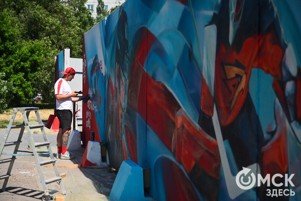 На бетонном заборе вокруг спорткомплекса имени Виктора Блинова теперь красуются красочные рисунки, отражающие историю ХК "Авангард". Фото: Илья Петров